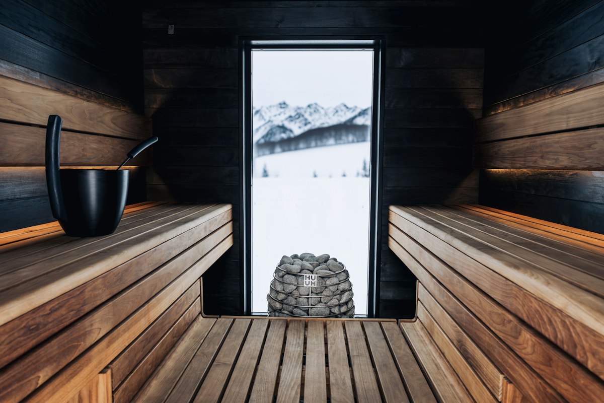 A wooden sauna with a window and a stack of warming rocks — the inspiration for many 2026 bathroom heating makeovers